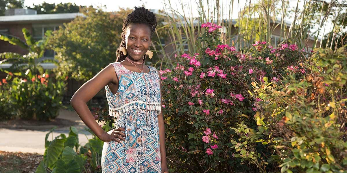 Noks Shabalala standing in front of flowers.