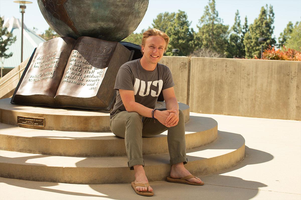 Nathan MacGregor sitting by the globe