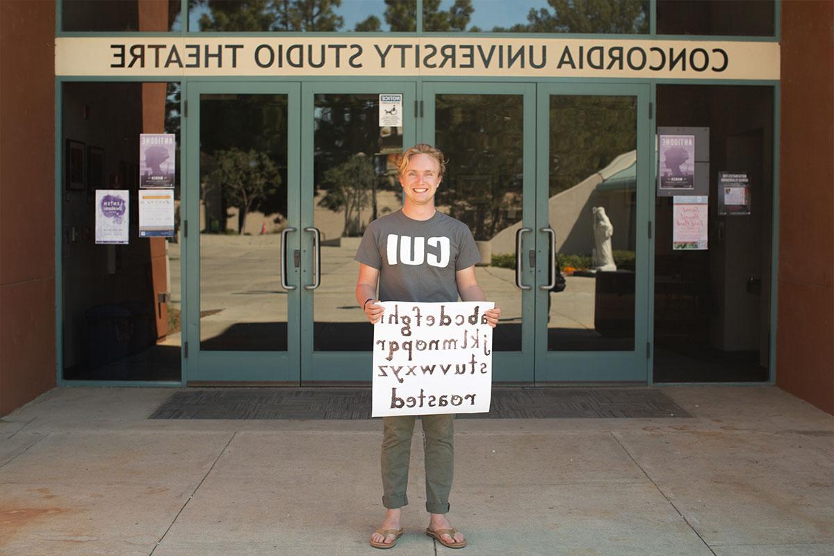 Nathan MacGregor standing with one of his project in front of the theatre